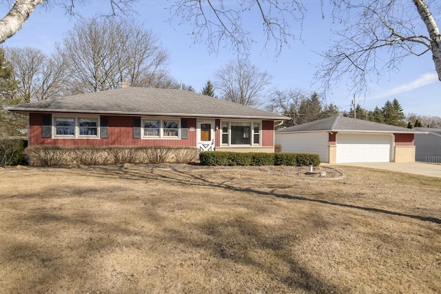 ranch-style home with an outbuilding, roof with shingles, concrete driveway, a front lawn, and a garage