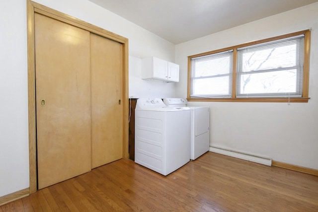 laundry room featuring cabinet space, washing machine and dryer, light wood-style floors, and baseboards