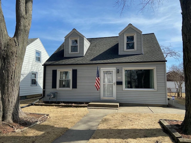 new england style home with roof with shingles