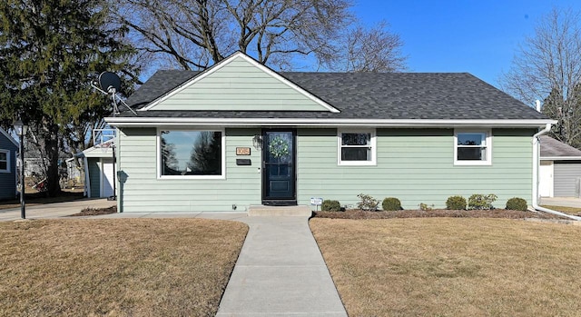 bungalow-style house with a shingled roof and a front lawn