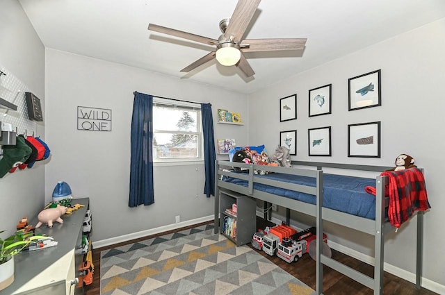 bedroom with ceiling fan, baseboards, and wood finished floors