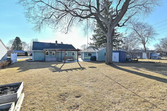 back of property with an outbuilding, a storage unit, a yard, and a chimney