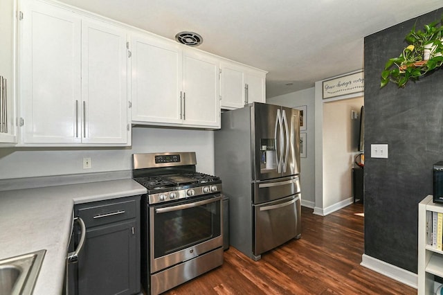 kitchen featuring visible vents, dark wood-type flooring, light countertops, stainless steel appliances, and white cabinetry