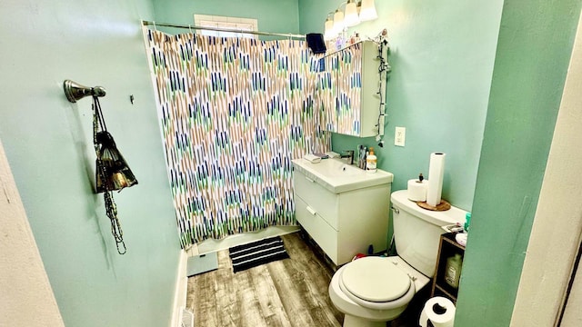 bathroom with a shower with curtain, wood finished floors, toilet, and vanity