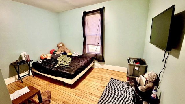 bedroom with baseboards and wood-type flooring