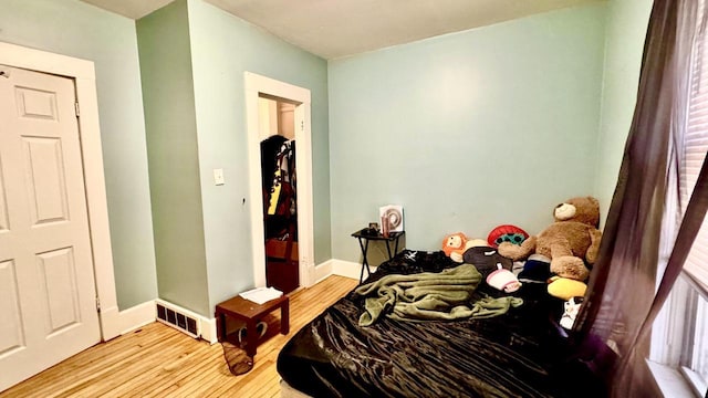 bedroom featuring visible vents, baseboards, and wood finished floors