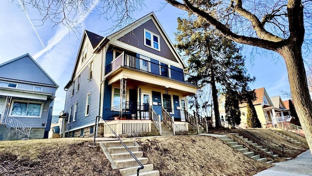 view of front of home featuring covered porch, stairs, and a balcony