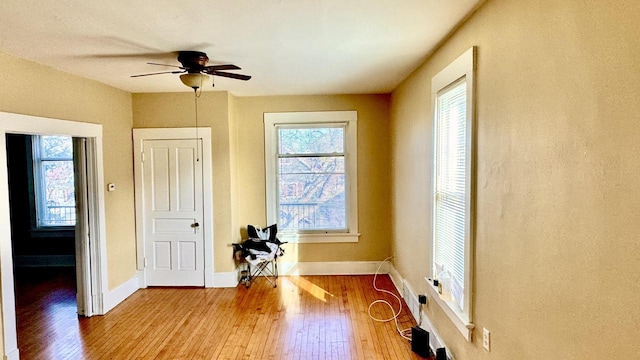 interior space with ceiling fan, baseboards, and hardwood / wood-style flooring