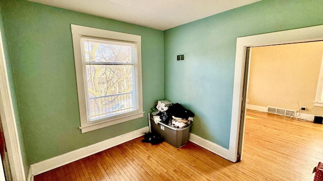 interior space with light wood-type flooring, visible vents, and baseboards