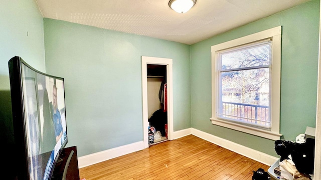 bedroom featuring light wood-style floors, baseboards, and a closet