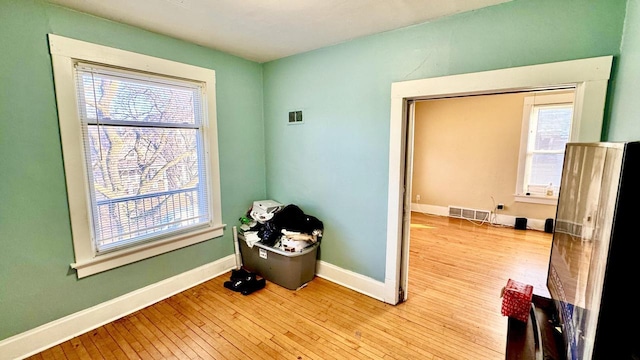 interior space featuring baseboards, visible vents, and light wood finished floors