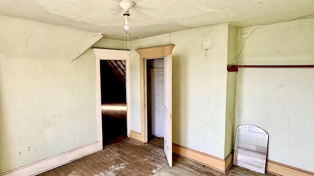 spare room with heating unit, lofted ceiling, and hardwood / wood-style floors