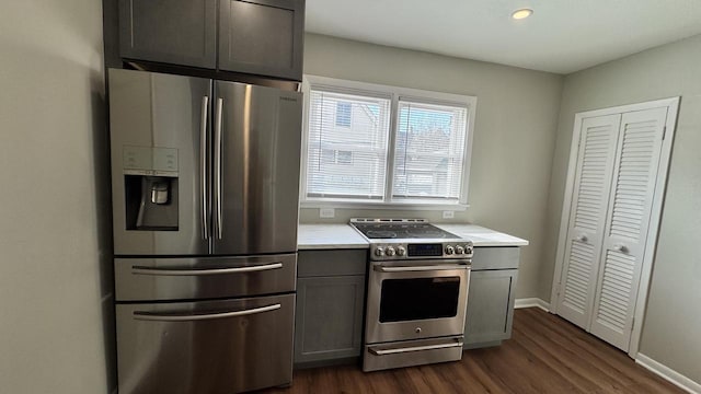 kitchen with gray cabinetry, dark wood finished floors, stainless steel appliances, light countertops, and baseboards