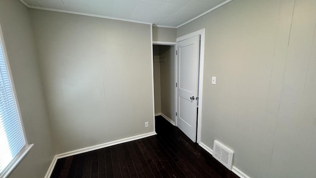 unfurnished bedroom with visible vents, baseboards, and dark wood-style floors