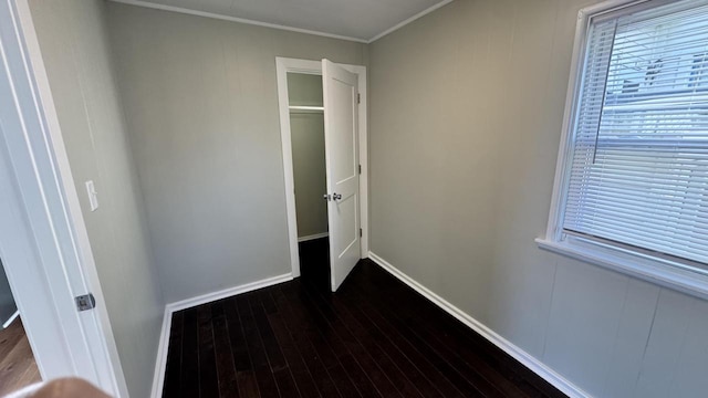 interior space with dark wood-type flooring, baseboards, and ornamental molding