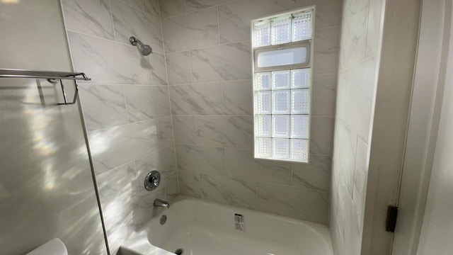 bathroom featuring a wealth of natural light and  shower combination