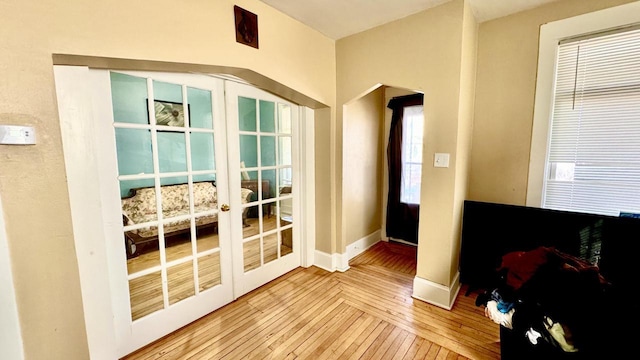 doorway with french doors, wood-type flooring, and baseboards