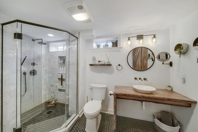 full bath with baseboards, a stall shower, a sink, tile patterned floors, and toilet