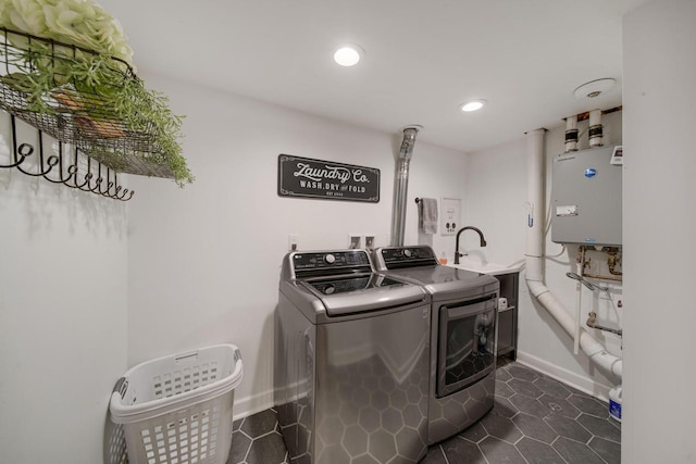 washroom with baseboards, laundry area, recessed lighting, dark tile patterned floors, and washer and clothes dryer