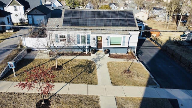 view of front facade with solar panels and fence