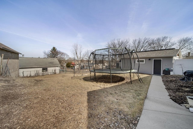 view of yard featuring a trampoline and fence