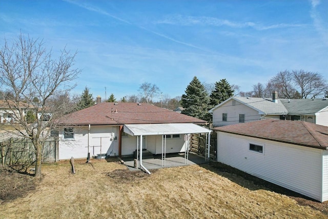 back of property featuring fence, a patio area, and a lawn