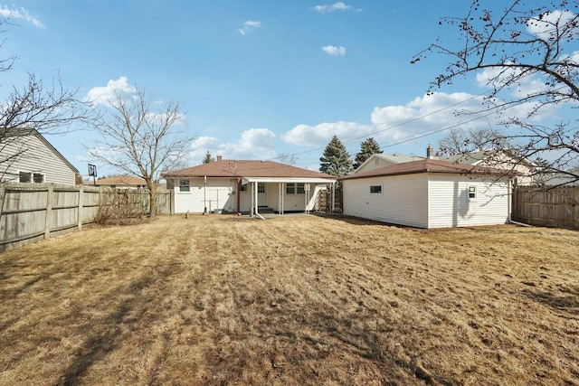 back of property with an outbuilding, a lawn, and a fenced backyard