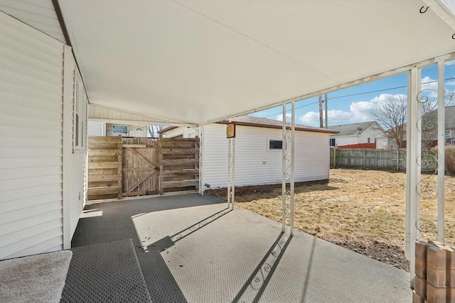 view of patio with fence, an outdoor structure, and a gate