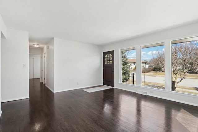 spare room with visible vents, baseboards, and wood finished floors