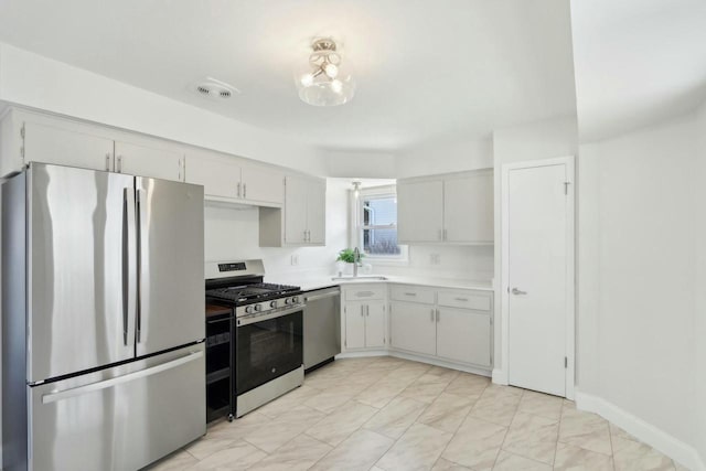 kitchen with visible vents, a sink, stainless steel appliances, light countertops, and a chandelier