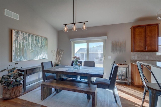 dining room featuring light wood-style flooring, baseboards, and visible vents