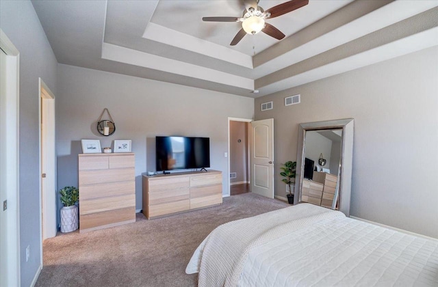 bedroom with visible vents, a raised ceiling, and carpet flooring