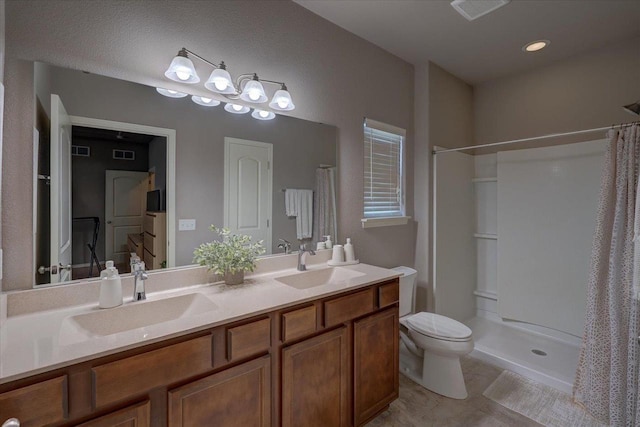 bathroom featuring a shower with curtain, toilet, visible vents, and a sink