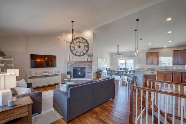 living room with recessed lighting, high vaulted ceiling, wood finished floors, and a fireplace