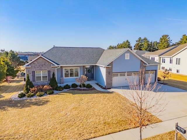 view of front of home featuring a front yard, an attached garage, brick siding, and driveway