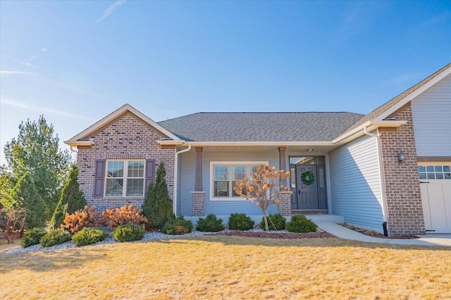 single story home with brick siding, an attached garage, a shingled roof, and a front yard