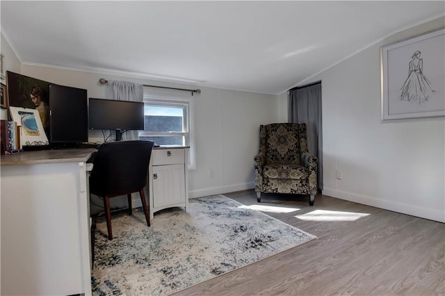 office featuring baseboards, built in study area, vaulted ceiling, crown molding, and light wood-type flooring