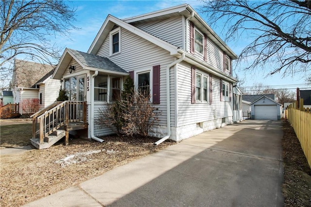 view of front of home with fence, driveway, a sunroom, an outdoor structure, and a garage