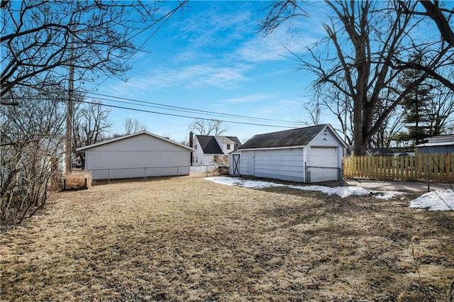 view of yard with an outdoor structure, fence, and a garage