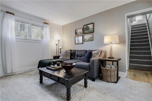 living area with stairs, baseboards, and wood finished floors