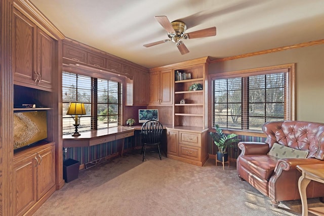 office area with ceiling fan, built in desk, and light carpet