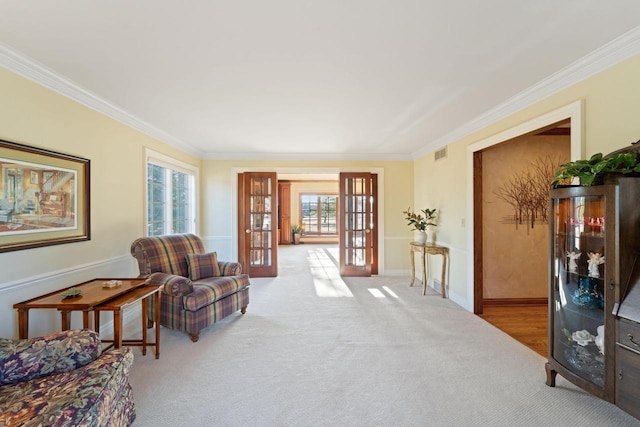 sitting room featuring visible vents, baseboards, french doors, crown molding, and carpet flooring