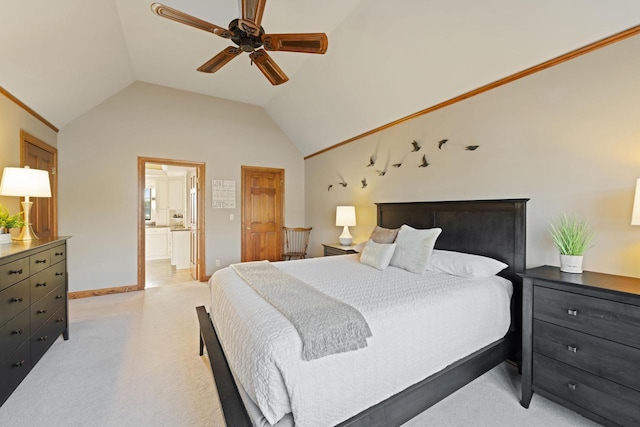 bedroom featuring baseboards, light colored carpet, vaulted ceiling, ensuite bath, and a ceiling fan