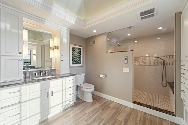 bathroom featuring vanity, wood finished floors, toilet, and a walk in shower