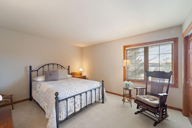 bedroom with light colored carpet and baseboards