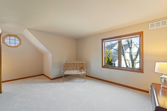 additional living space with light carpet, visible vents, and baseboards