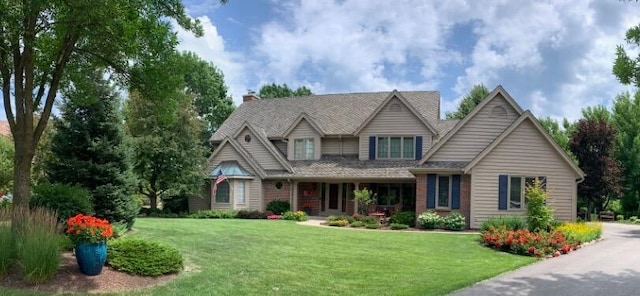 view of front facade with brick siding and a front yard