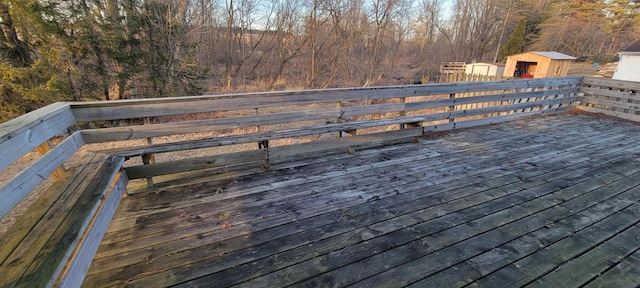 wooden deck featuring a forest view and an outdoor structure