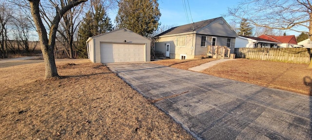 view of front facade with an outbuilding, aphalt driveway, a detached garage, and fence