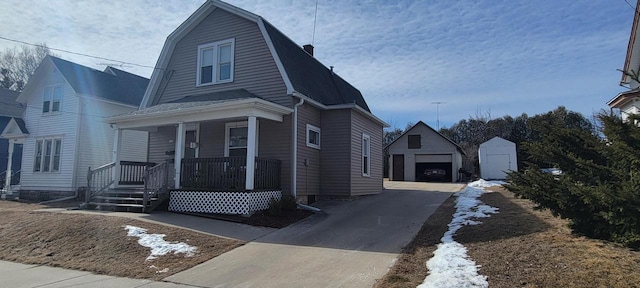 dutch colonial featuring a gambrel roof, a porch, a garage, an outdoor structure, and driveway